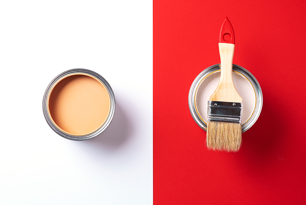 wooden paint brush and open paint cans